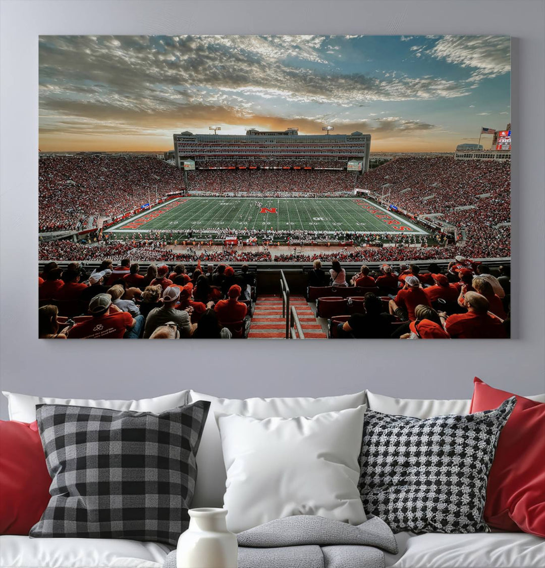 The living room features a stunning triptych of Lincoln Memorial Stadium wall art canvas print, celebrating the University of Nebraska Cornhuskers football team. This piece serves as captivating wall art, showcasing a gallery-quality finish.