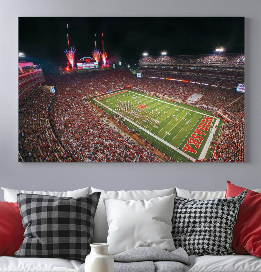 The University of Nebraska Cornhuskers Football Team Print, featuring Lincoln Memorial Stadium in a vibrant triptych canvas with fireworks above and a gallery-quality finish, is elegantly displayed.