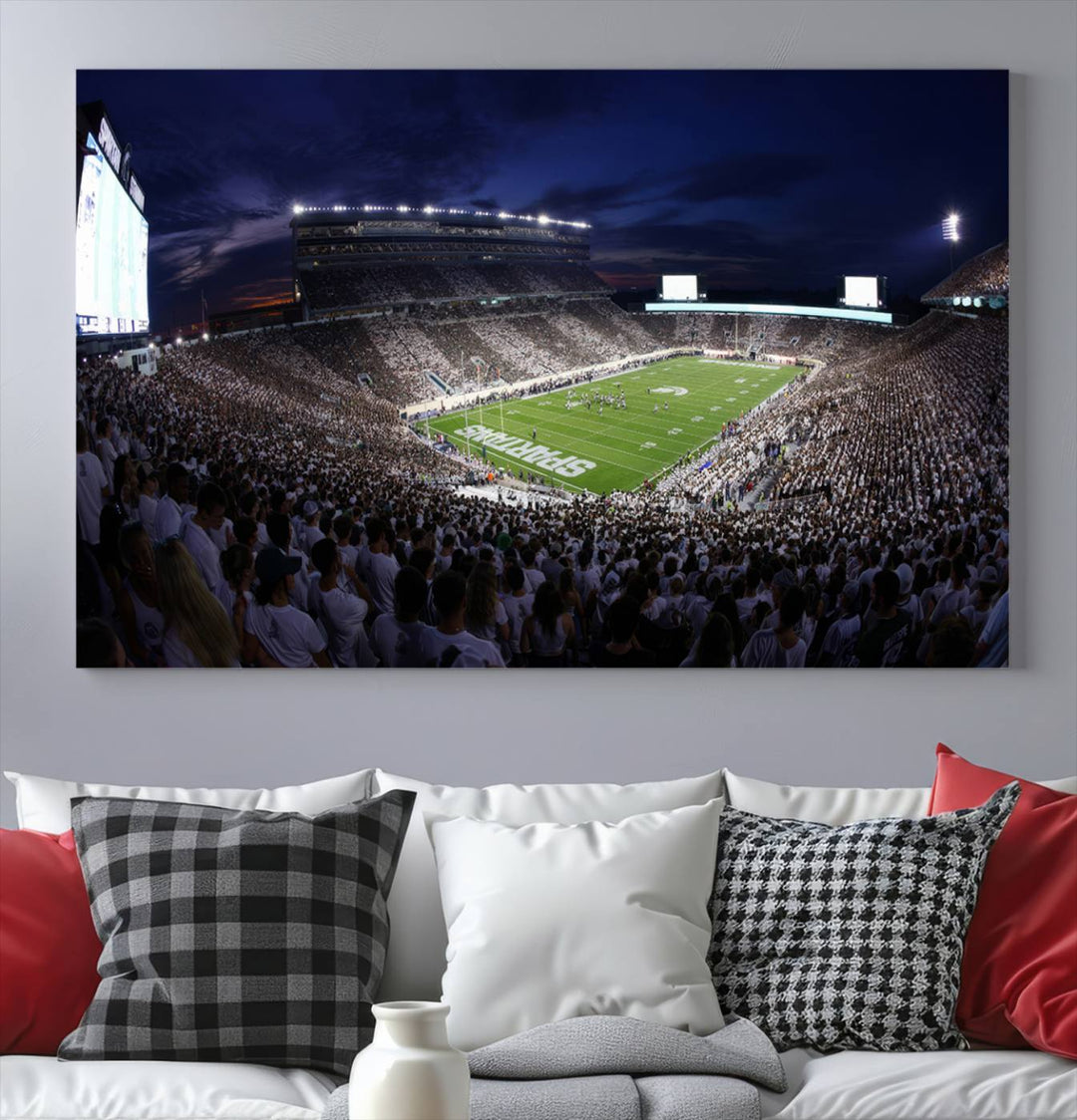 A packed football stadium at night, with bright lights and fans in white, depicted in a Michigan State Spartans Stadium wall art.