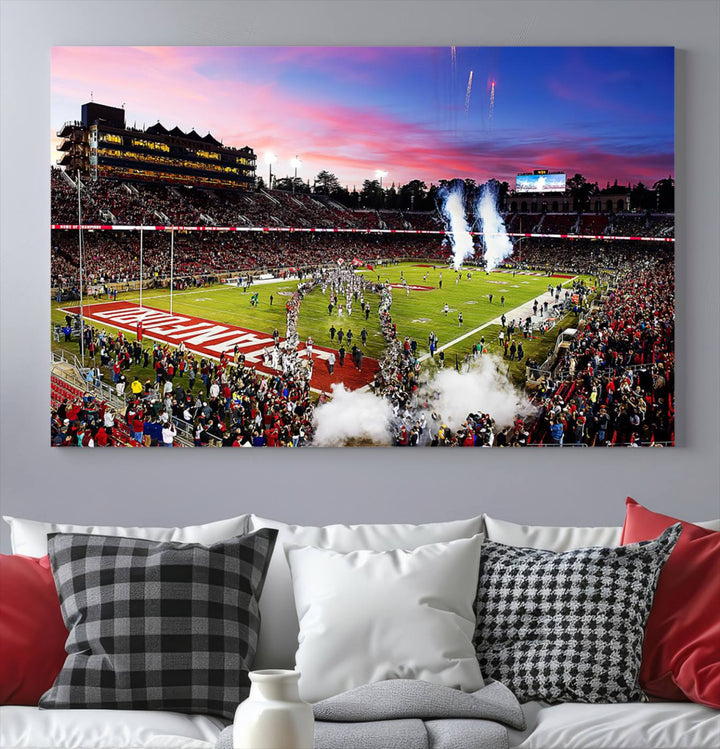 The wall art features a canvas print of the Stanford Cardinal football team, capturing players, fireworks, and smoke against the backdrop of a sunset at Stanford Stadium.