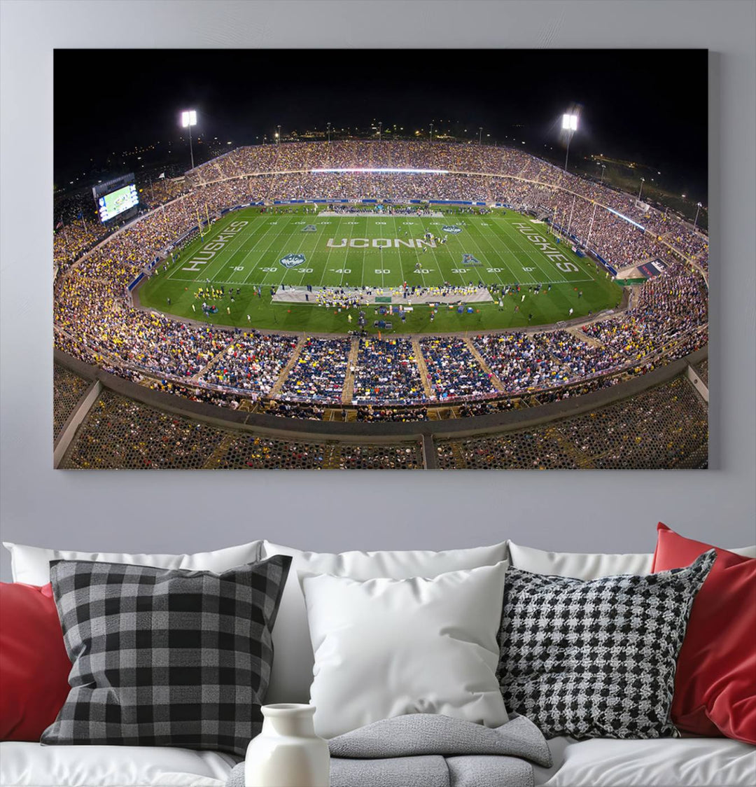 A large football stadium at night, featuring the UCONN Huskies, is depicted on the East Hartford Pratt & Whitney Stadium Wall Art Canvas Print.