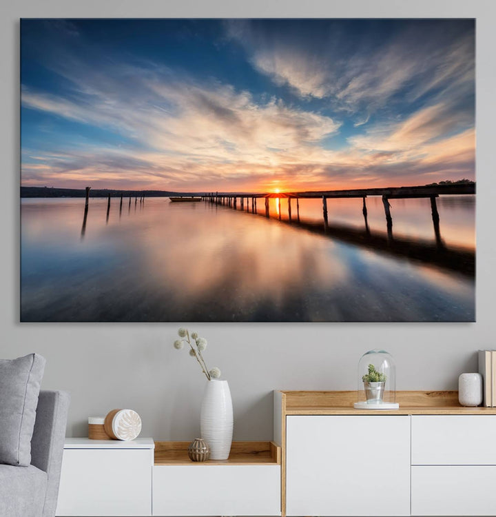 The Sunset Pier Canvas features a serene coastal landscape with vibrant hues under cloudy skies, ideal for modern decor.