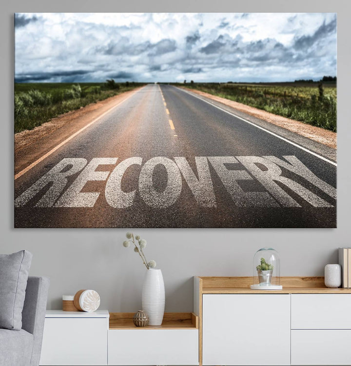 The Recovery Road Wall Art Canvas Print depicts a road under a cloudy horizon.