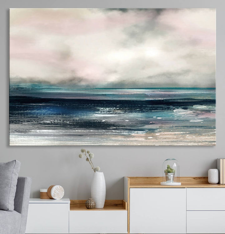 A contemporary abstract wall art canvas print in pastel pink, teal, and gray tones hangs on the wall.