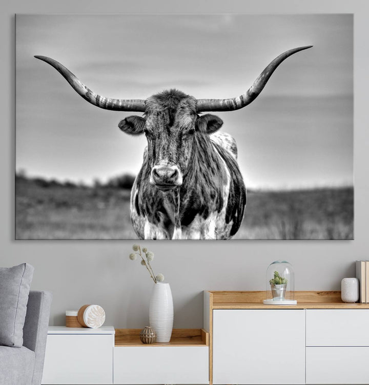 The Texas Longhorn Cow wall art, divided into three panels, is of gallery quality and displayed on a dark wall.