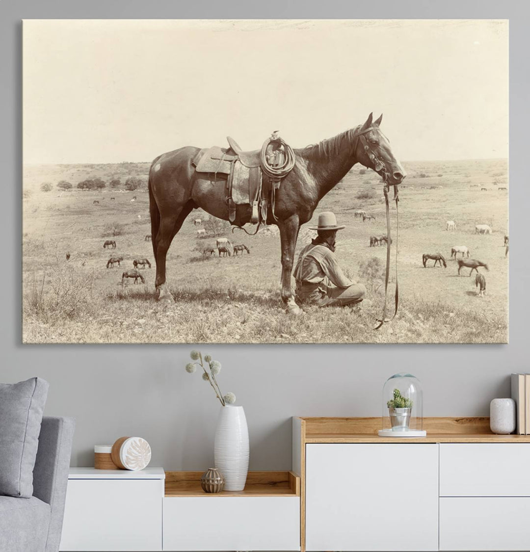 Cowboy Wall Art - Vintage Western Horse Canvas Print features a cowboy kneeling by his horse in a field.