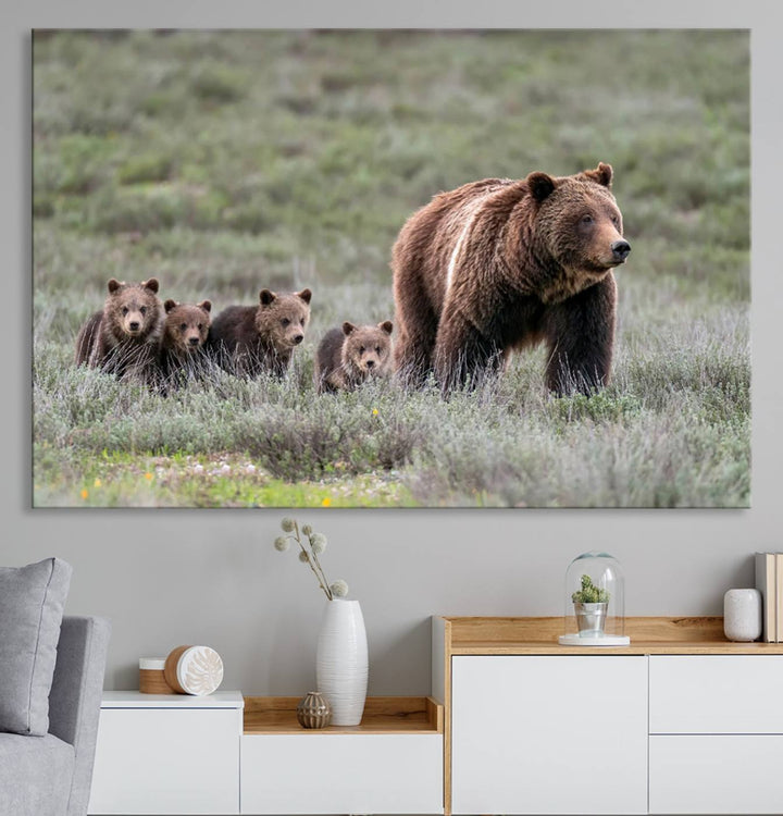 The large canvas print titled "Queen of the Tetons, 399 Grizzly Bear Cubs" showcases majestic wildlife photography of a bear and her cubs walking through the grass. This stunning canvas wall art, handmade in the USA, adds a charming touch to any room with its rustic decor appeal.