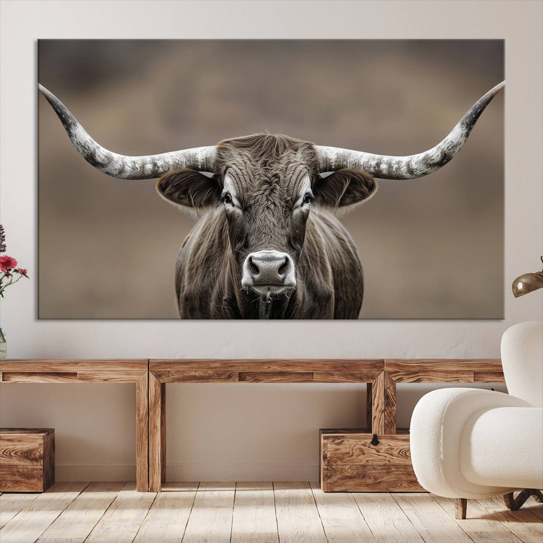 A close-up of a longhorn bull facing forward is featured in the Framed Texas Test-1, set against a blurred brown background.