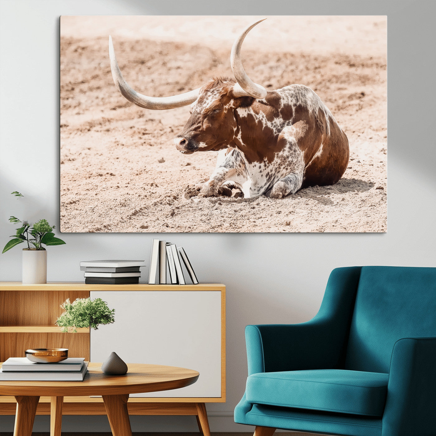 Texas Longhorn bull resting on dusty ground with warm tones, ideal for rustic western or farmhouse-themed wall decor.