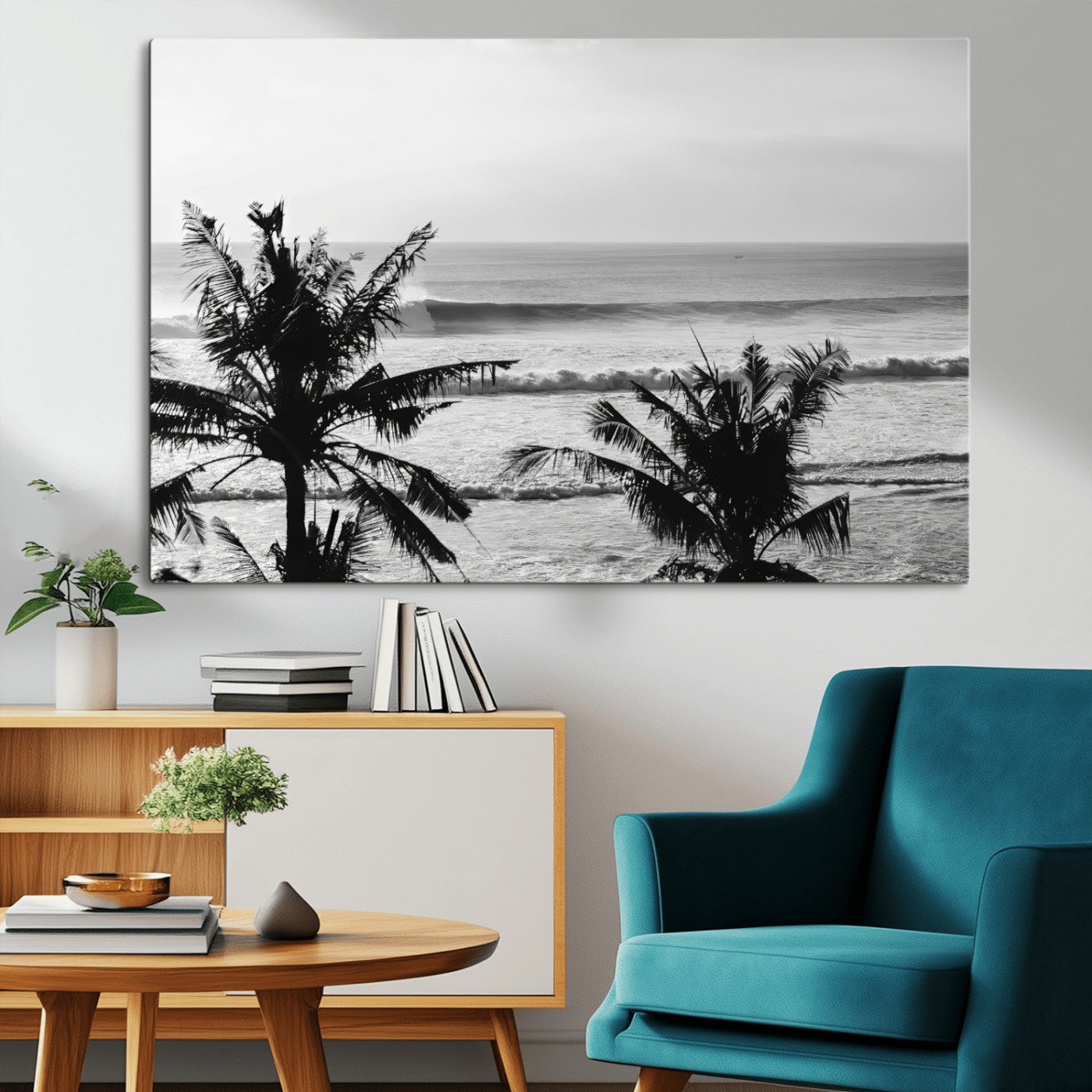 Black and white view of ocean waves crashing on a tropical coastline, framed by silhouetted palm trees under a vast, open sky.