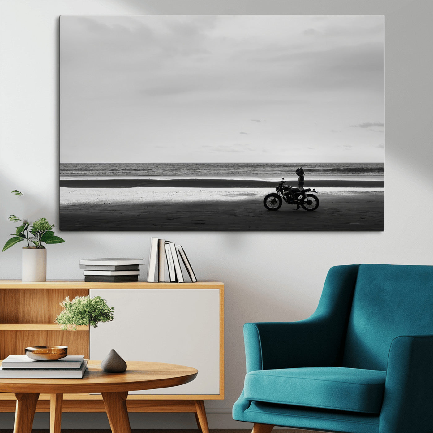 A motorcyclist on a vast beach, gazing at the ocean, capturing a moody and tranquil coastal adventure in black and white.