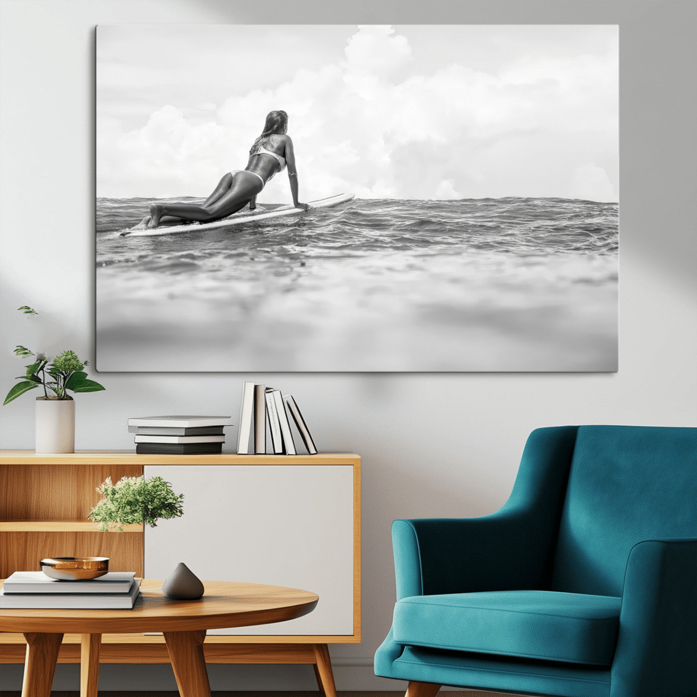 A black and white ocean scene featuring a surfer girl waiting on her board, gazing at the horizon, capturing a tranquil and adventurous coastal moment.