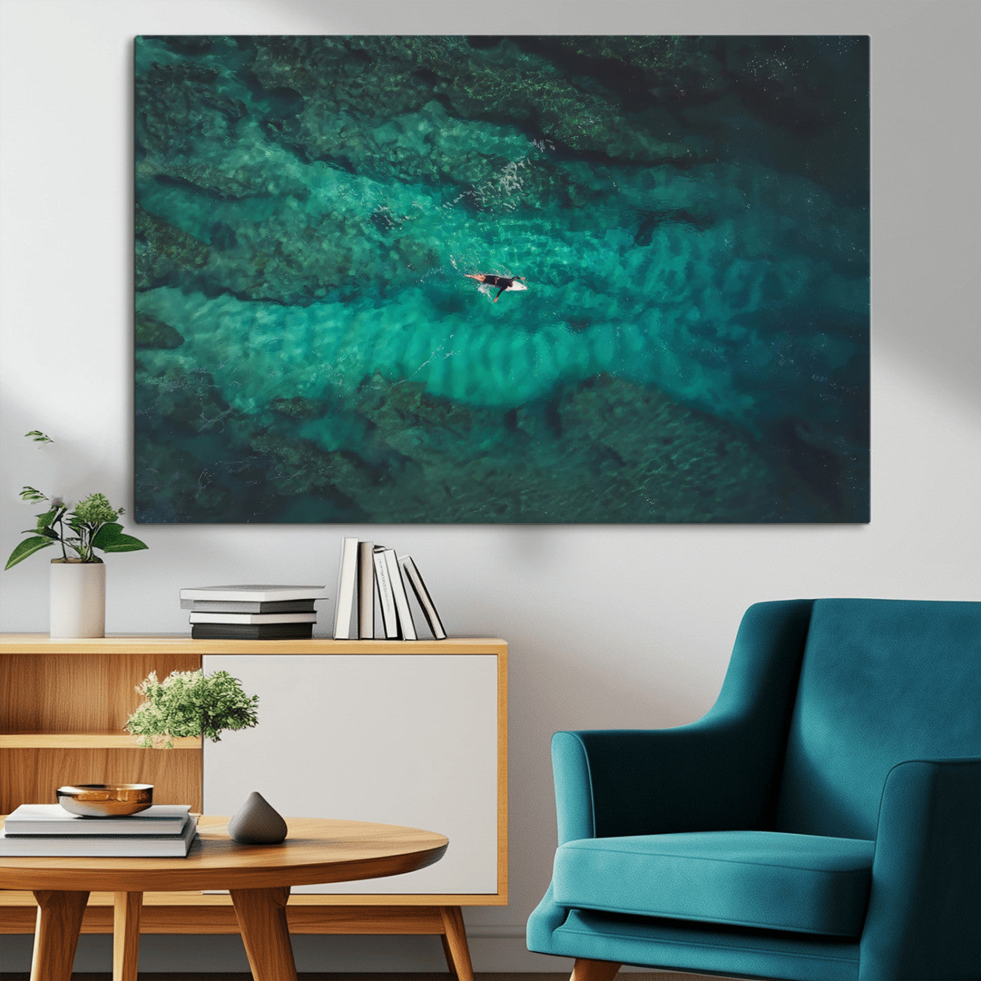 An aerial view of a solo surfer paddling through crystal-clear turquoise waters over a sunlit reef, capturing the beauty and serenity of open water surfing.