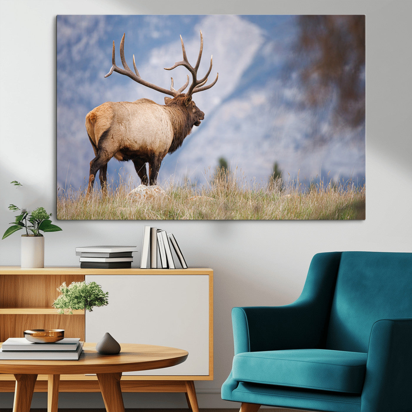 Elk with antlers standing on grass with mountain background, ideal for rustic, cabin, or lodge-inspired wall decor.