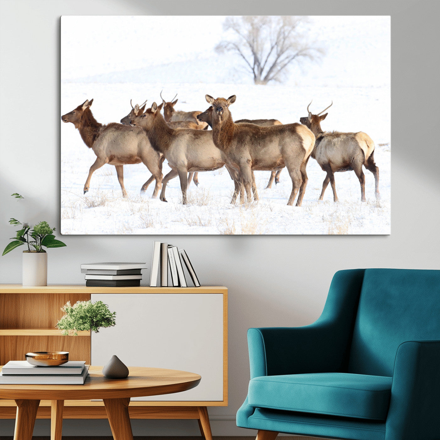 A group of elk standing on snowy terrain with a tree in the background, perfect for rustic or lodge-style winter wall decor.