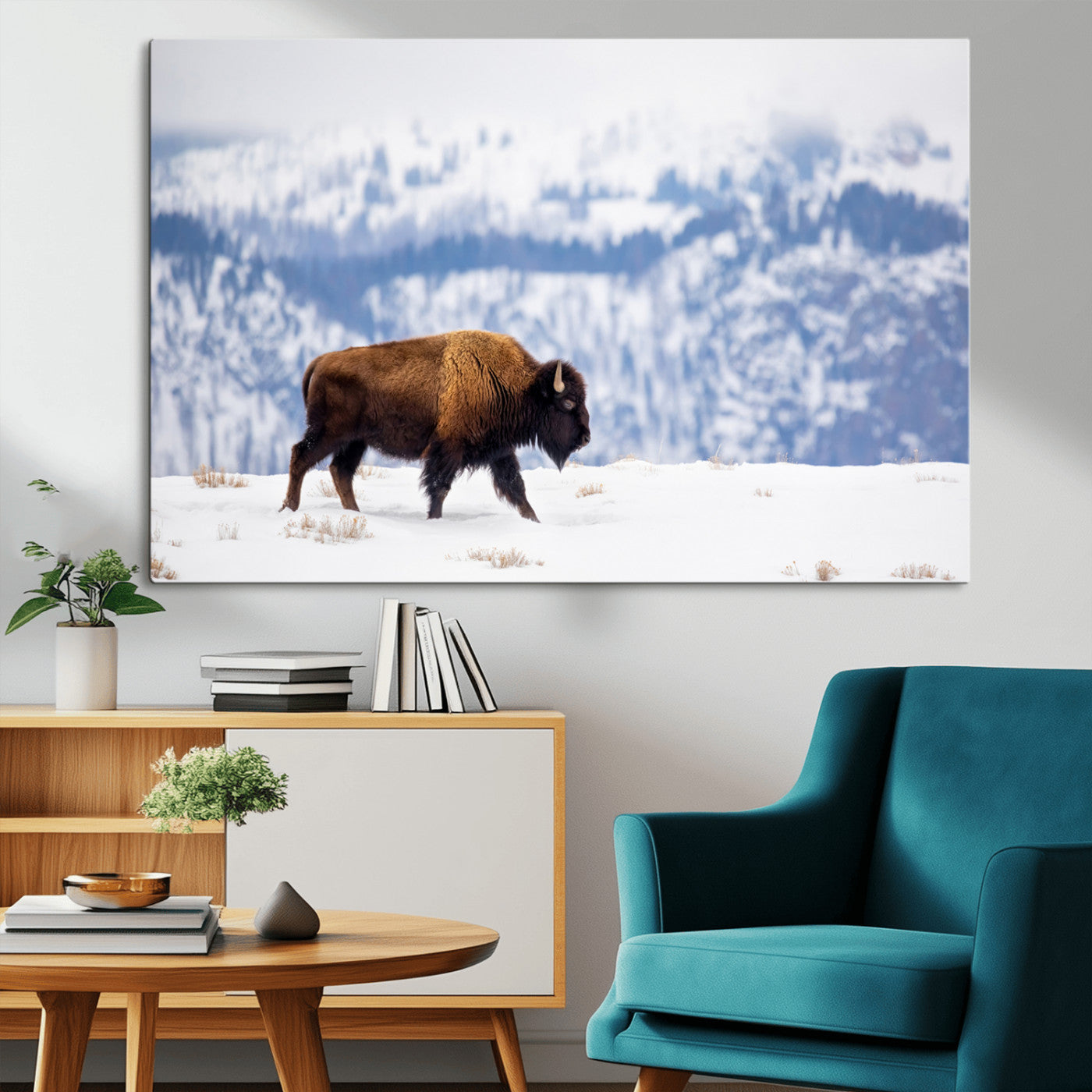A lone bison walks across snowy ground with blue-toned mountain range behind, ideal for rustic or western farmhouse interiors.