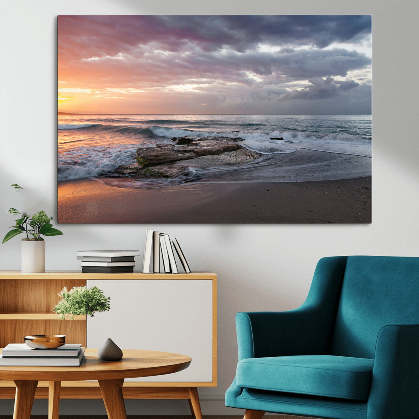 Dramatic sunset over a rocky shoreline with ocean waves gently reaching the sandy beach, creating a serene and coastal atmosphere.