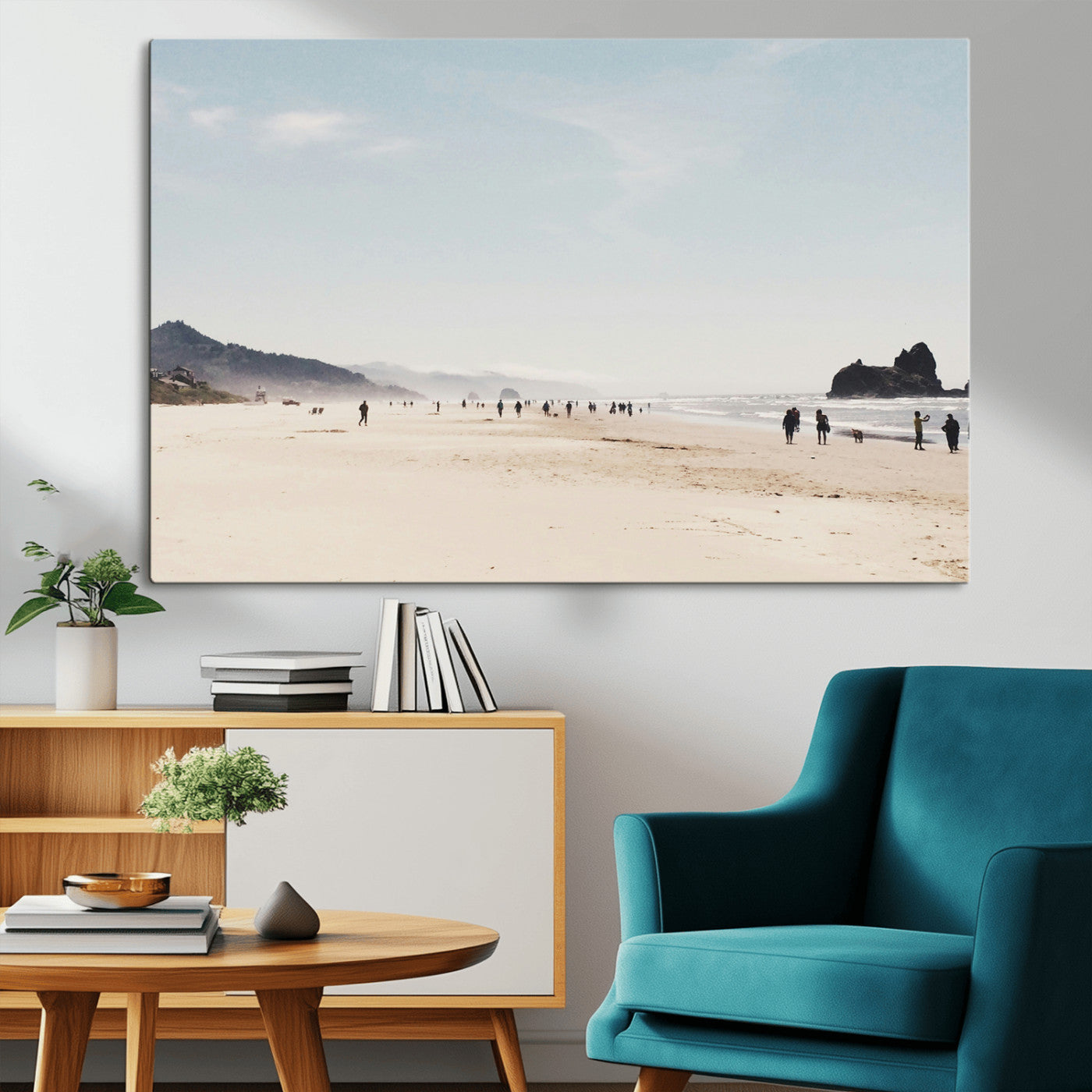A serene beach with soft sand, misty mountains, and scattered people walking along the shoreline, creating a peaceful coastal landscape.