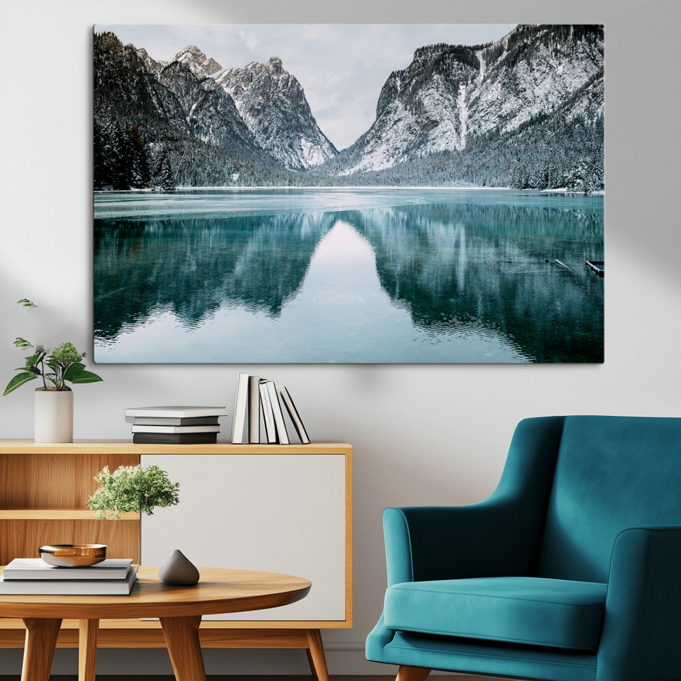 Crystal-clear alpine lake reflecting snow-covered mountains, surrounded by evergreen trees, creating a serene and tranquil winter landscape.