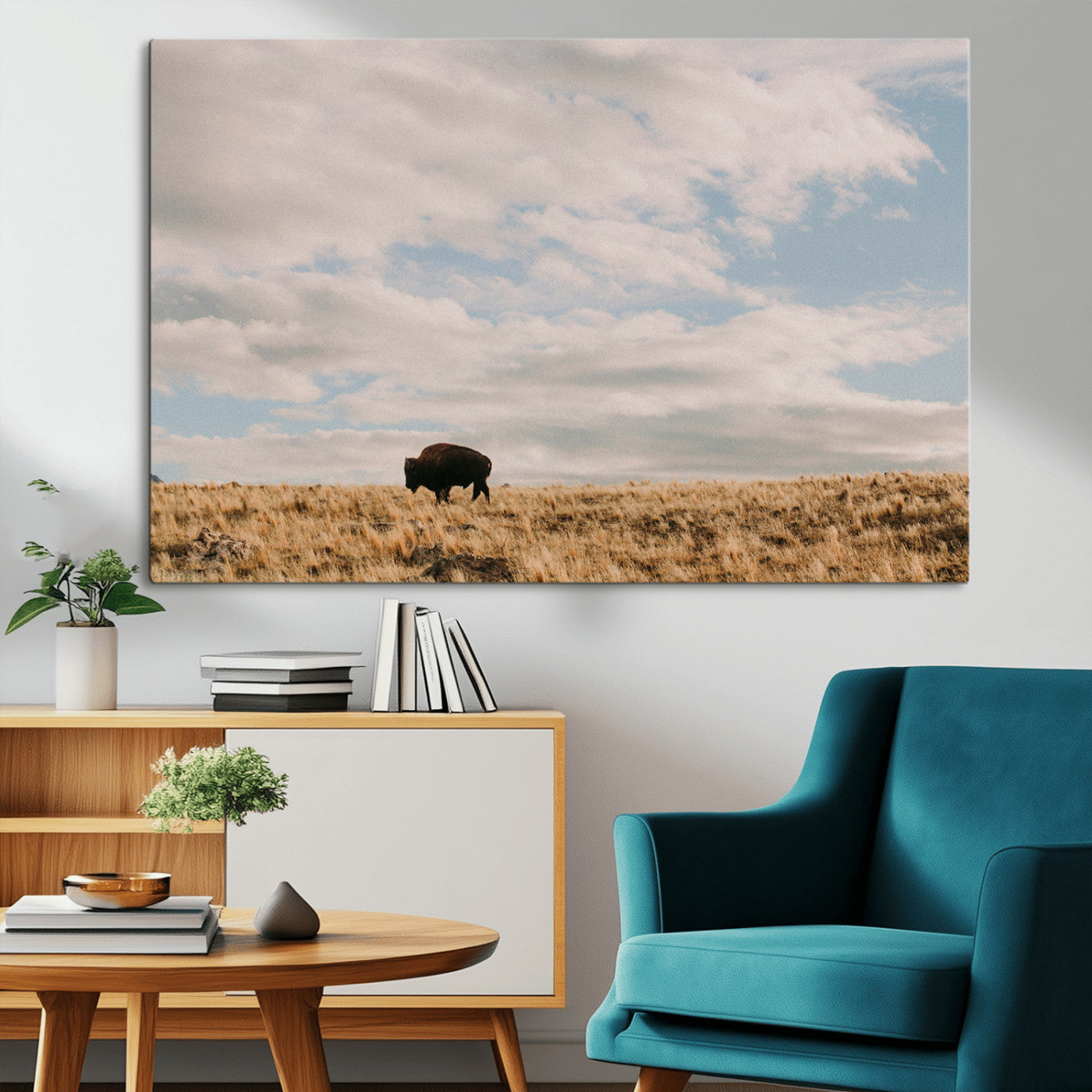A solitary bison walking across a golden prairie under a vast, cloud-filled sky, evoking a peaceful, rustic western landscape for home decor.