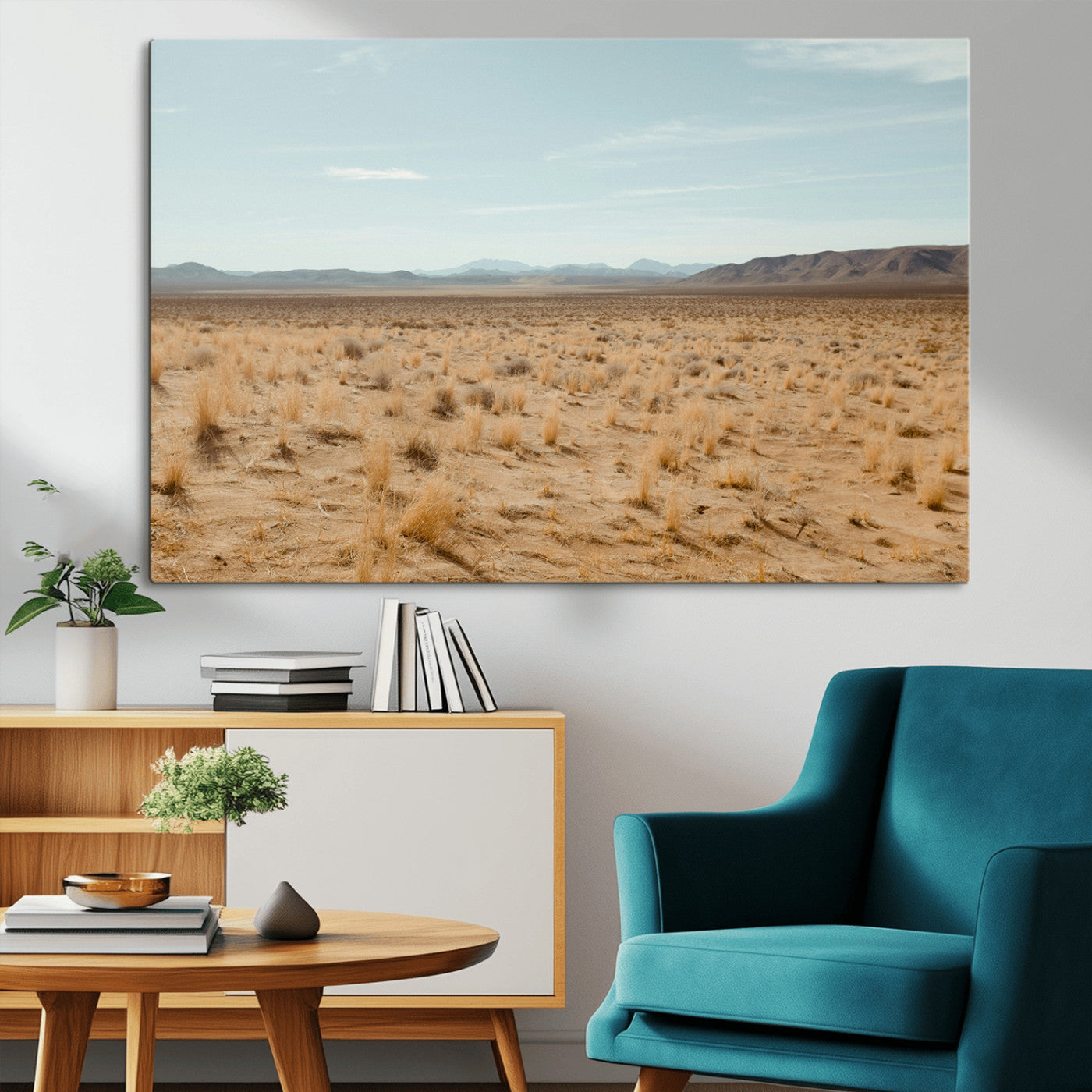 Expansive desert landscape with scattered dry grass and distant mountain range under a pale blue sky – Wall Art Canvas Print.