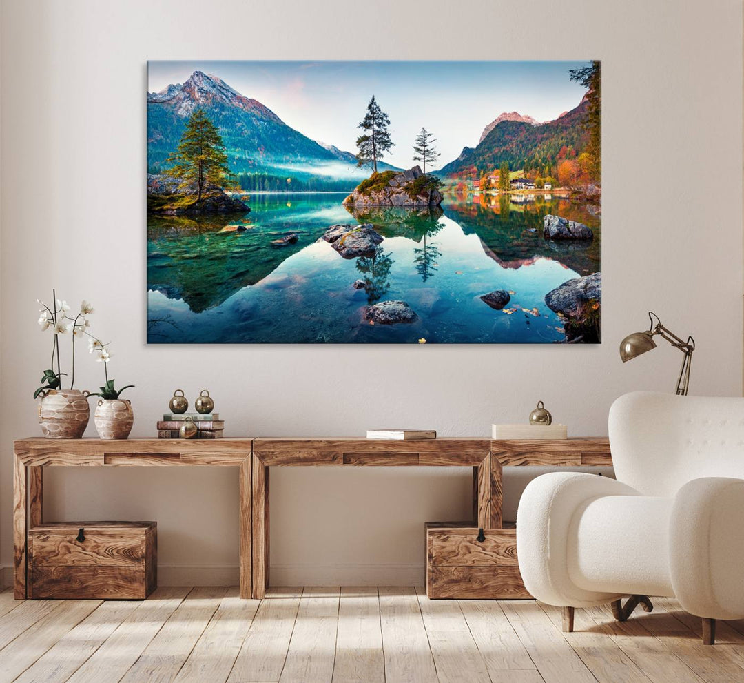 The 3-panel wall art showcases a serene mountain lake with rocky islands and trees, creating an ideal focal point for dining rooms or offices.