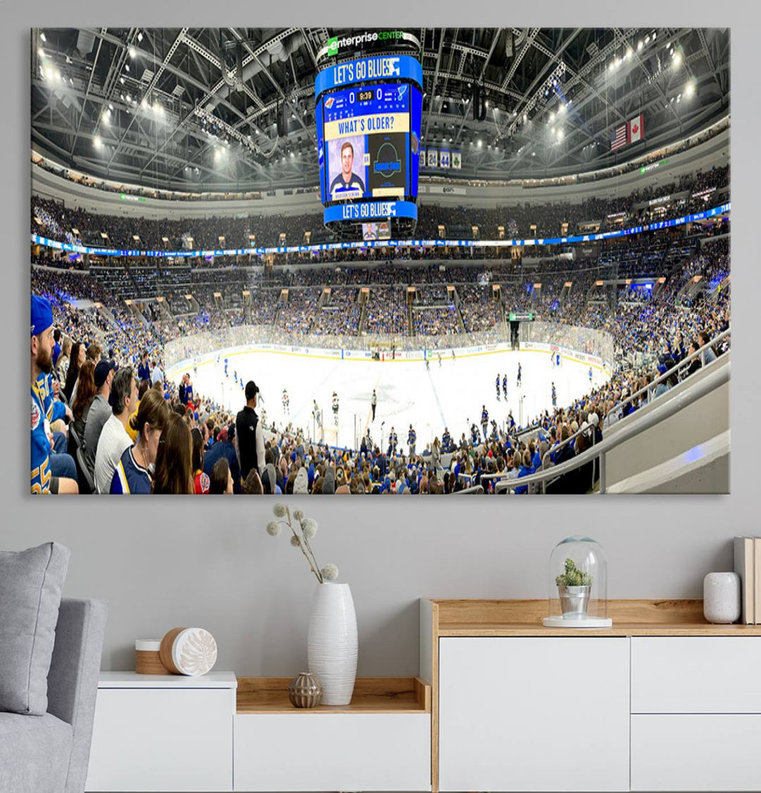 Wall art prints depicting the bustling scenes of the St. Louis Blues being cheered on by a full house at the Enterprise Center, beneath a large scoreboard.