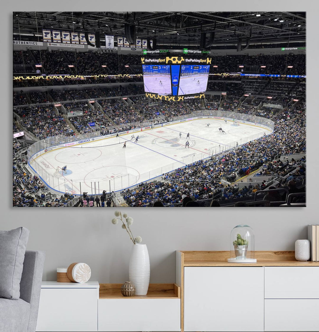 A large Enterprise Center canvas of a crowded hockey arena hangs prominently.