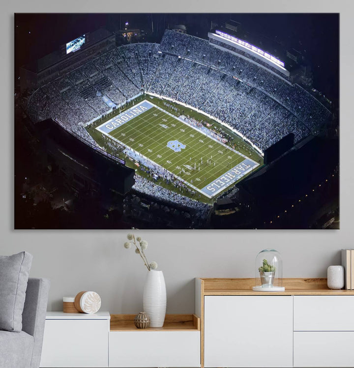 A University of North Carolina Tar Heels Football Team Print, showcasing Chapel Hill's Kenan Memorial Stadium, hangs in a modern dining room, adding a gallery-quality finish that enhances the entire space.