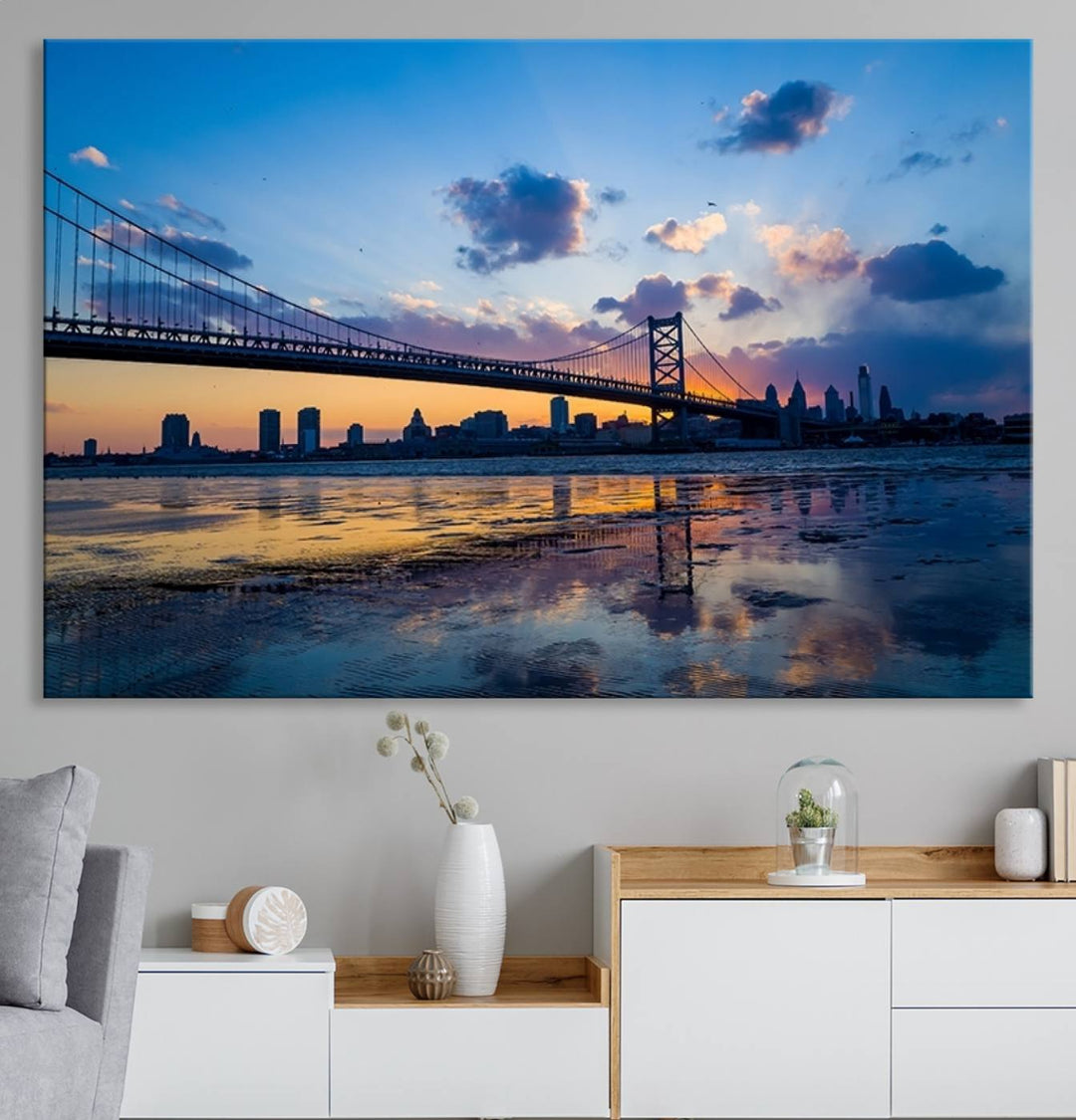 A photograph titled "Large Wall Art Philadelphia Canvas Print - Benjamin Franklin Bridge at Sunset" displays a breathtaking cityscape of the bridge reflected in the water. This image features a gallery-quality finish that promises to transform any space into an evocative memory.