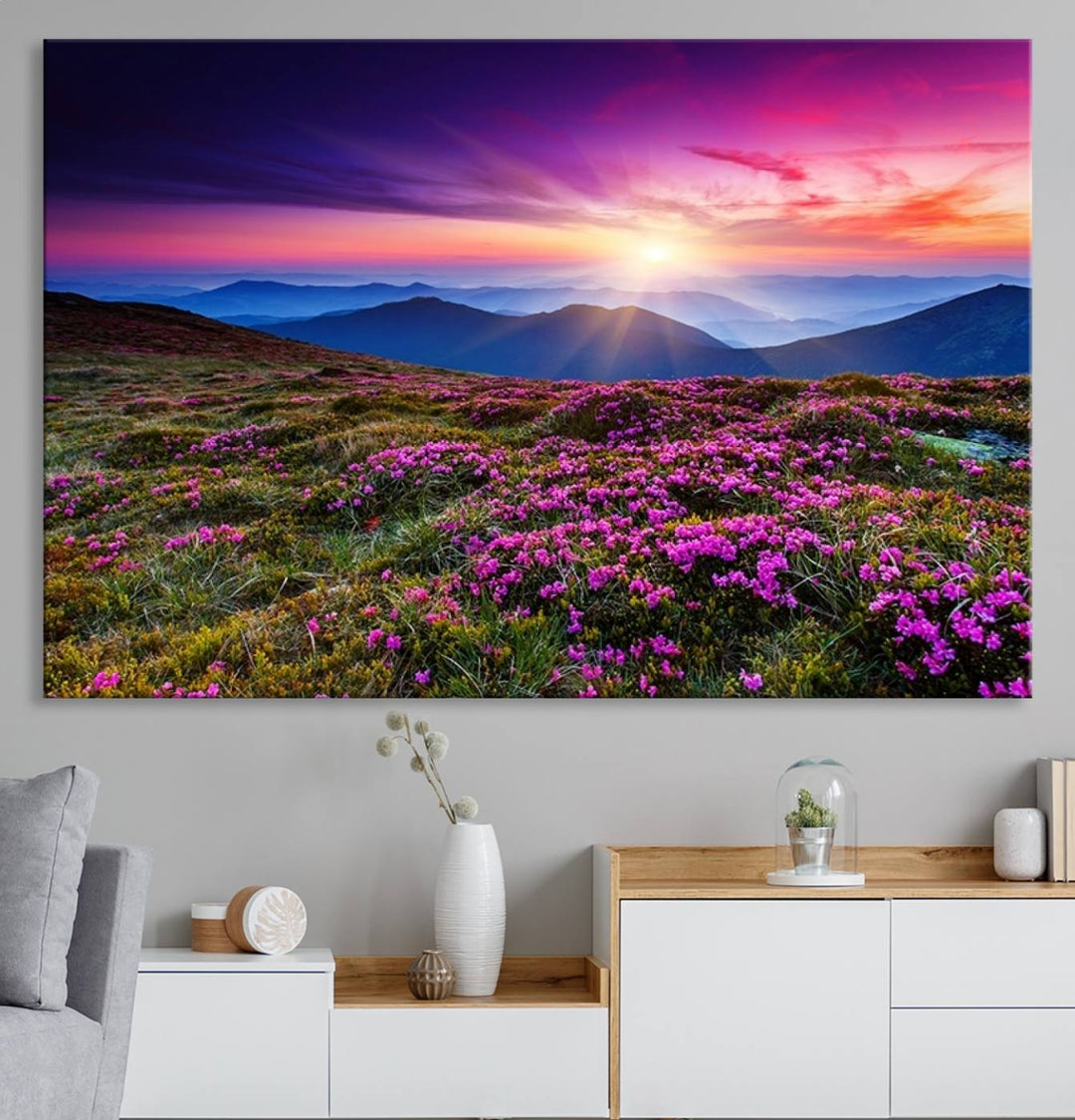 A 3-panel landscape photography canvas of a sunset over mountain meadows with purple wildflowers decorates the wall.