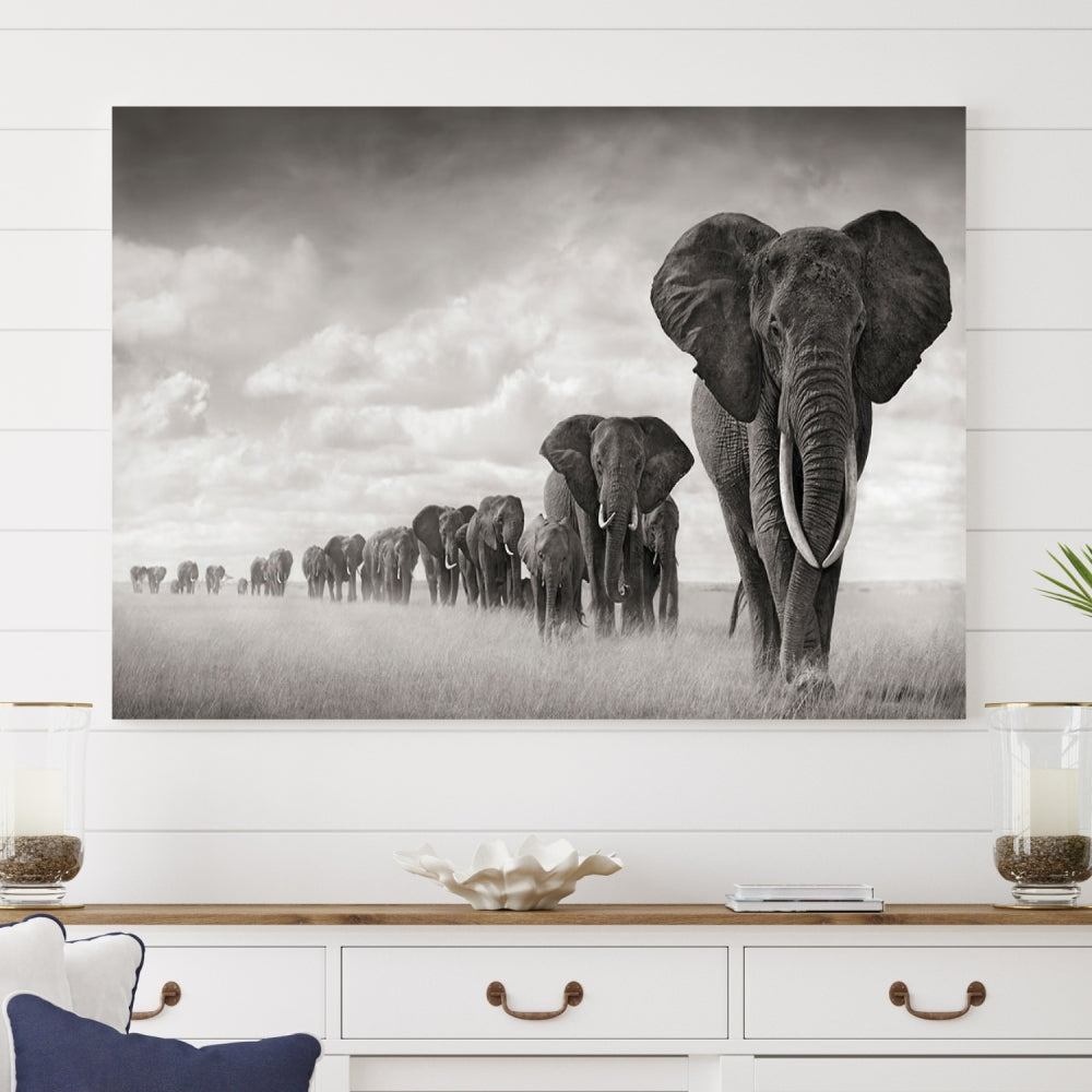 The "Herd of Elephants Wall Art Canvas Print" features an elegant black and white triptych of elephants walking in a line, beautifully displayed on museum-quality canvas with a UV-protective coating. This artwork arrives ready to hang and adds sophistication to any space.