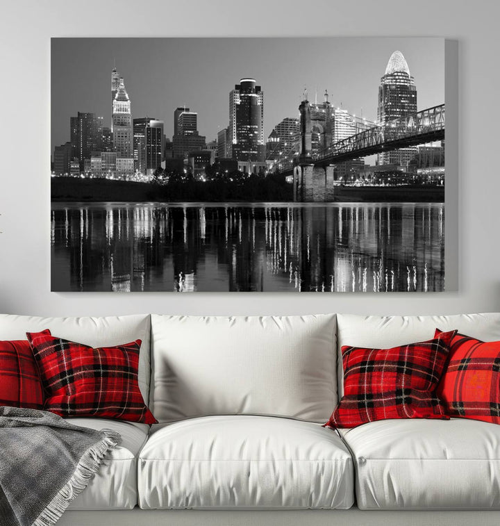 The wall showcases a ready-to-hang triptych of the Cincinnati City Lights Skyline in black and white, printed on museum-quality canvas.