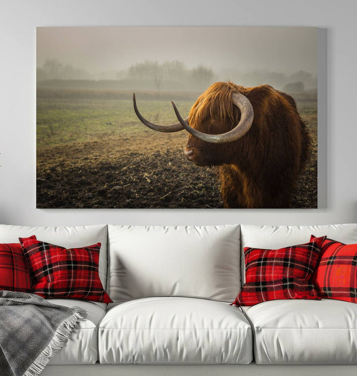 The "Big Cow Horn Wall Art Canvas Print" is a hand-assembled framed canvas depicting a Highland cow in a misty field. It is crafted with a UV-protective coating to ensure lasting vibrancy.