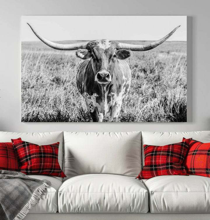 The Texas Cow Longhorn Wall Art Canvas Print is a black and white triptych depicting a cow in a field. It is crafted with museum-quality canvas and features a UV-protective coating.