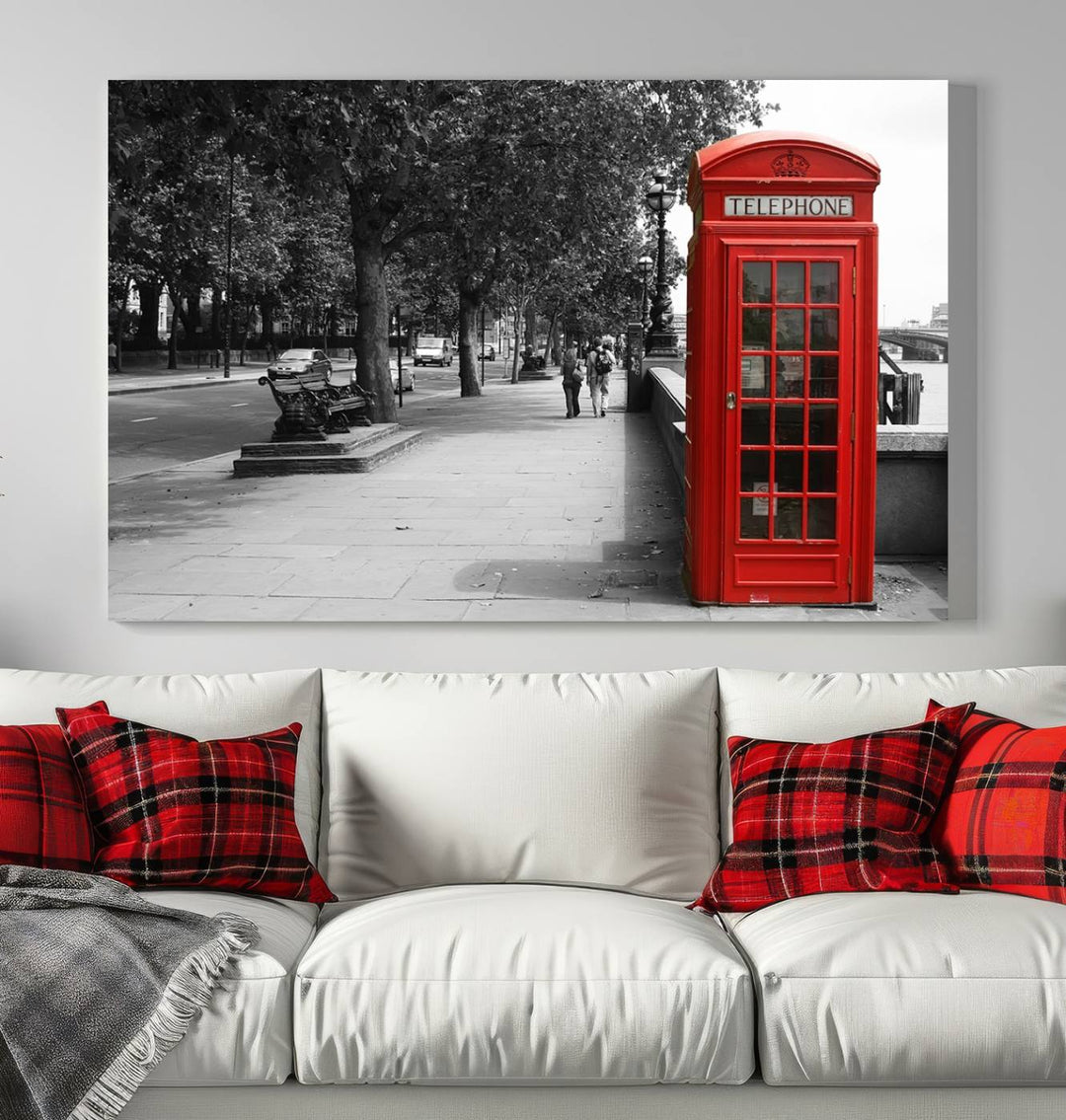 The London Phone Club Wall Art is a stunning piece that showcases a red telephone box set in a black and white street scene on museum-quality canvas. It is gallery wrapped with a UV-protective coating to preserve its vibrant charm.