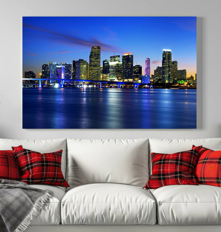 The modern living room showcases a striking Miami Blue Night Wall Art canvas print on the wall. The artwork is gallery wrapped on museum-quality canvas, ensuring durability and elegance.