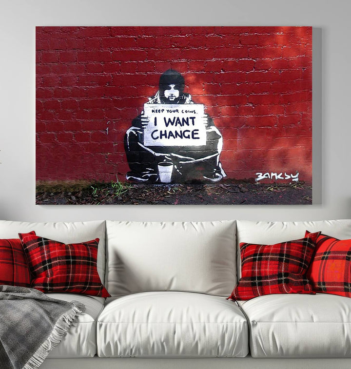 The living room showcases a triptych of stencil artwork on museum-quality canvas, featuring the Banksy I Want Change Graffiti Abstract Wall Art Canvas Print. This captivating piece depicts a person holding a sign that says "I want change" and is finished with a UV-protective coating to ensure long-lasting beauty.