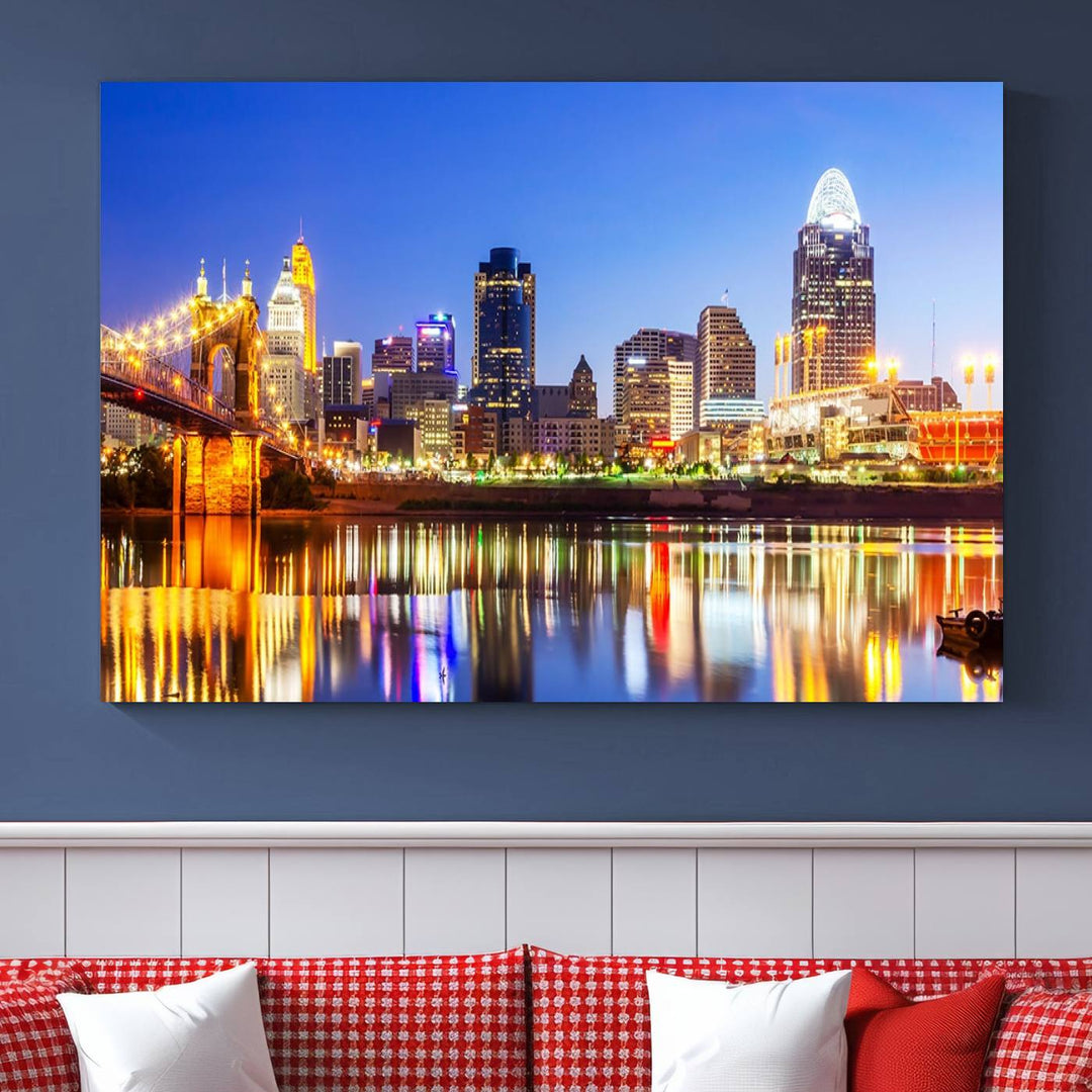 The "Cincinnati City Lights Night Skyline Cityscape View Wall Art Canvas Print" is a gallery-wrapped, museum-quality canvas illustrating a lit-up bridge and skyline at night. Enhanced with a UV-protective coating, this piece ensures lasting vibrancy.