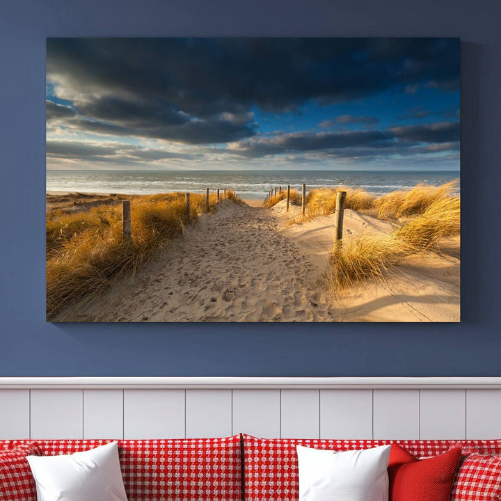 The Ocean Beach Dark Clouds Wall Art Canvas Print is a breathtaking triptych depicting a sandy beach path with tall grasses under an intense cloudy sky. It is crafted on museum-quality canvas with UV protection.