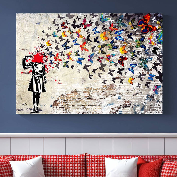 The Banksy Art Butterfly Girl Explosion Canvas showcases a dynamic figure with butterflies bursting from their head, set against a textured wall background. This vibrant urban graffiti piece is perfect for modern interiors and comes ready to hang.