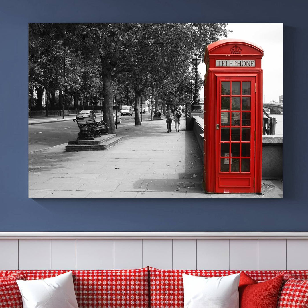 The London Phone Club Wall Art is a stunning piece that showcases a red telephone box set in a black and white street scene on museum-quality canvas. It is gallery wrapped with a UV-protective coating to preserve its vibrant charm.