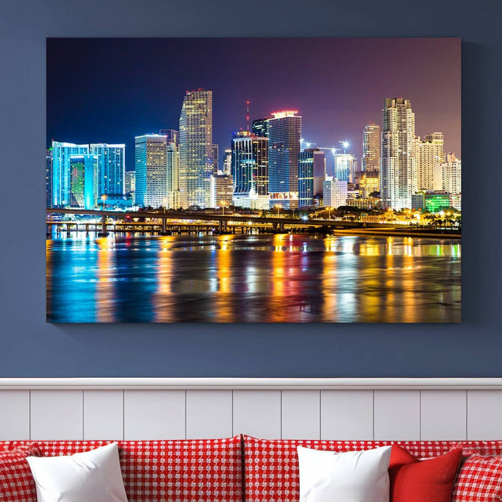 The Wall Art MIAMI Canvas Print features a stunning triptych of a city skyline at night, with vibrant lights reflecting on the water. This gallery-wrapped piece on museum-quality canvas delivers an exquisite finish.