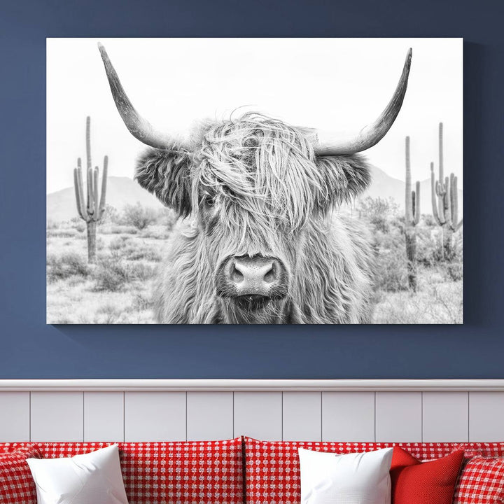 The "Rustic Charm | Cow Longhorn Black White Bighorn Wall Art Canvas Print" is a stunning triptych that showcases a highland cow with long horns set against a desert landscape with cacti in the background. This farmhouse wall art elevates any room into a rustic haven with its gallery-quality canvas.