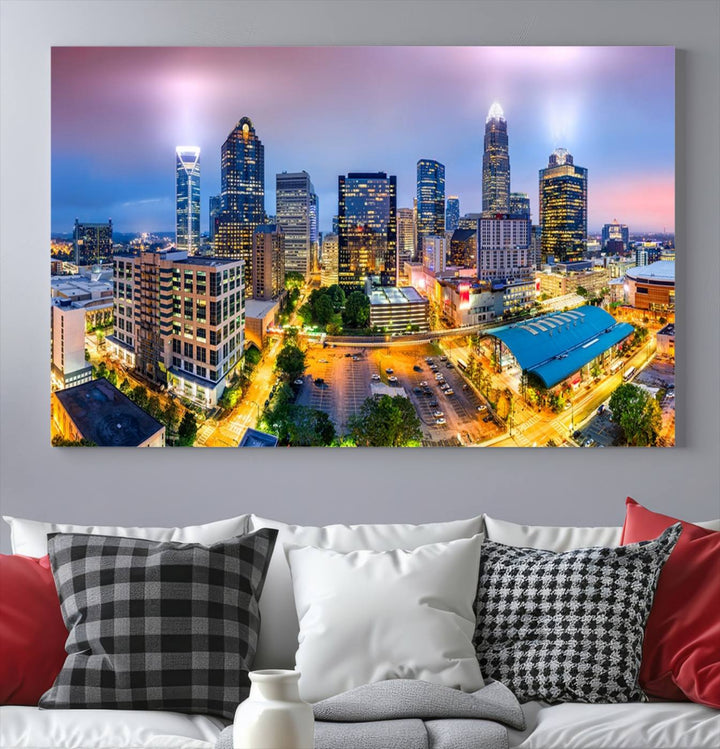 The living room features three large pieces of the *Charlotte City Lights Sunset Purple Skyline Cityscape View Wall Art Canvas Print*. Crafted on gallery-wrapped, museum-quality canvas with UV-protective coating, they grace the wall and add an artistic flair to the space.