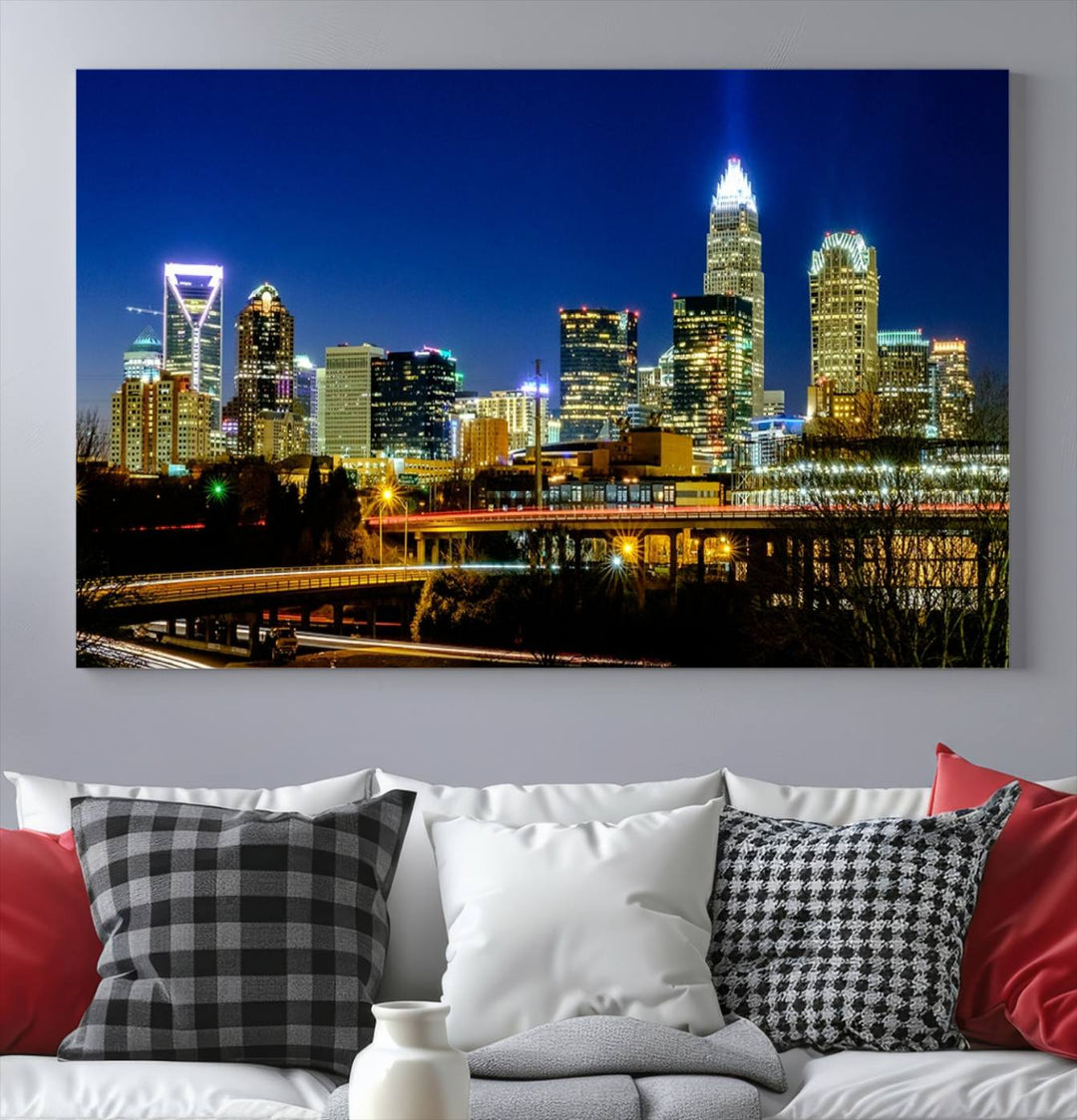 The Charlotte City Lights Night Blue Skyline Cityscape View Wall Art Canvas Print, showcasing an illuminated city skyline at night, is printed on museum-quality canvas with a UV-protective coating. Enhance your space with this stunning piece and enjoy free shipping with your purchase.