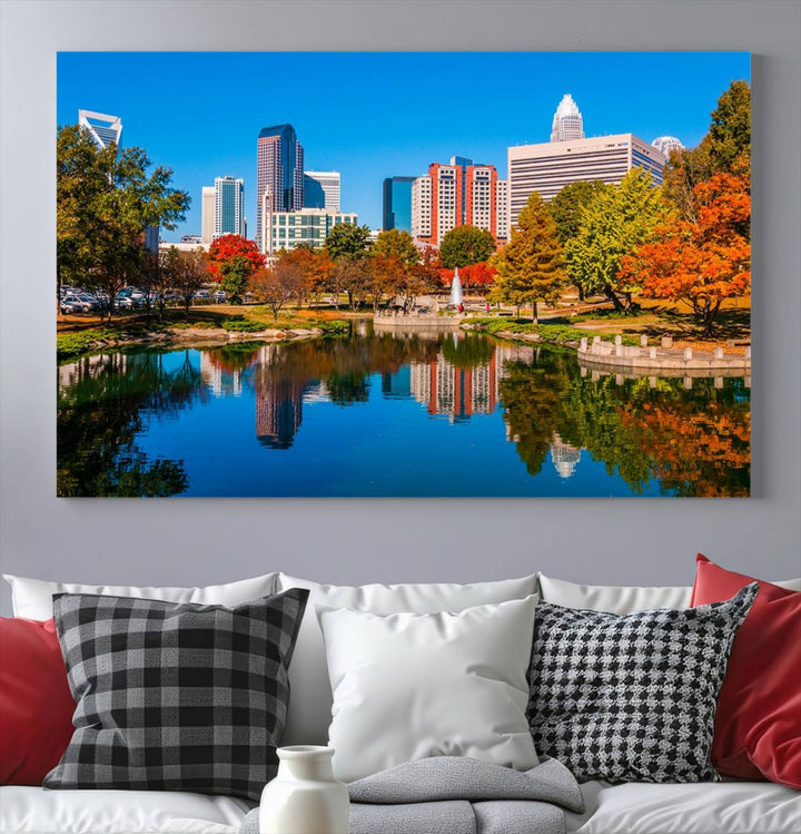 The "Charlotte City Autumn Morning Blue Skyline Cityscape View Wall Art Canvas Print" showcases a cityscape with vibrant autumn trees reflected in a lake. Its gallery-wrapped edges add depth to the scene, while the UV-protective coating ensures lasting brilliance.