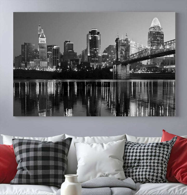 The wall showcases a ready-to-hang triptych of the Cincinnati City Lights Skyline in black and white, printed on museum-quality canvas.