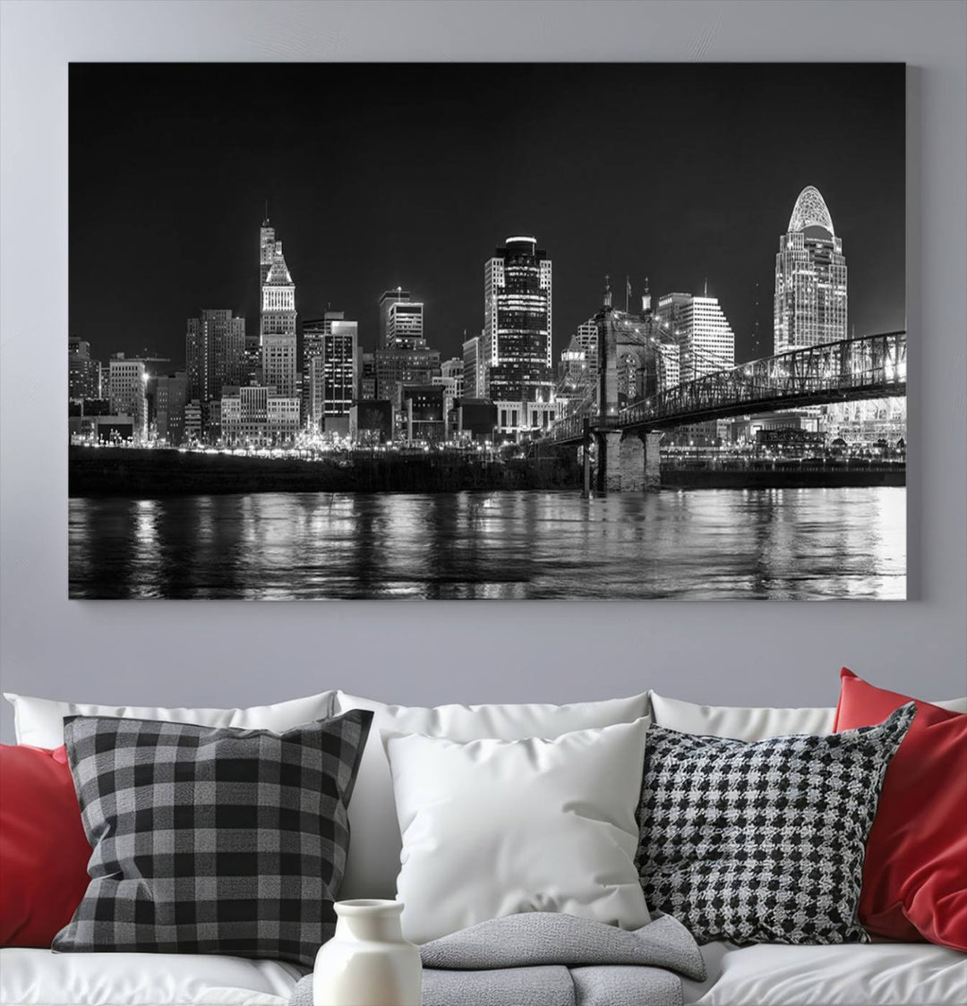 The Cincinnati City Lights Skyline Black and White Wall Art Cityscape Canvas Print elegantly adorns a modern living room. This museum-quality canvas triptych of a city skyline is enhanced by hand-assembled frames for added finesse, and you can enjoy free shipping on this stunning home addition.