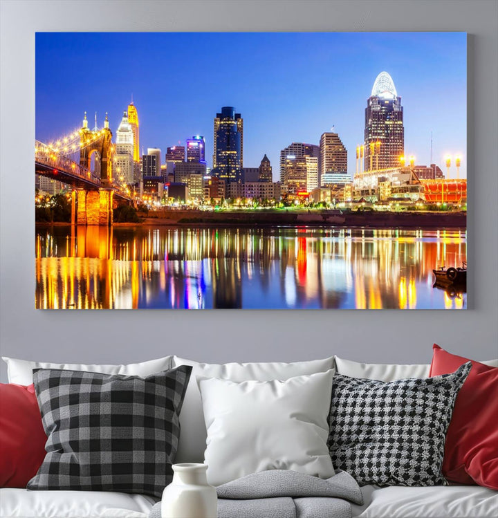 The "Cincinnati City Lights Night Skyline Cityscape View Wall Art Canvas Print" is a gallery-wrapped, museum-quality canvas illustrating a lit-up bridge and skyline at night. Enhanced with a UV-protective coating, this piece ensures lasting vibrancy.